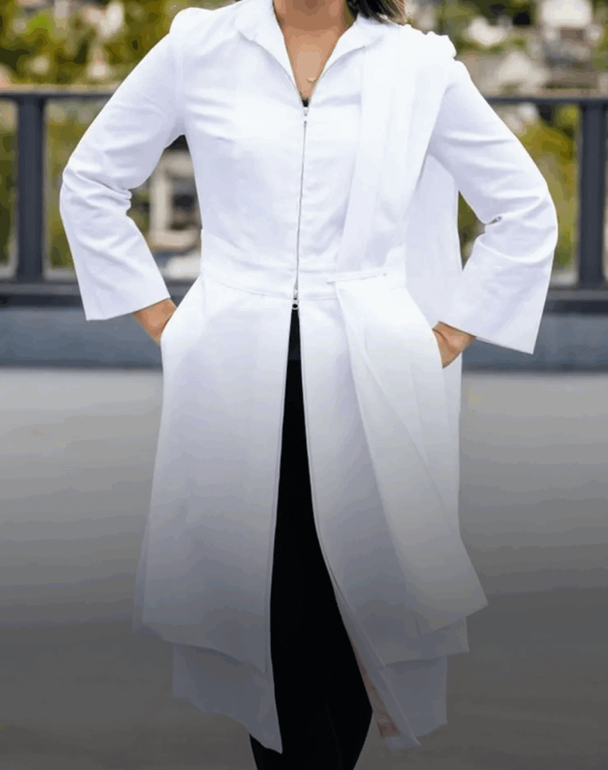 Person wearing a white lab coat outdoors.